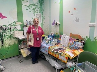 Woman in pink scrubs in emergency department with play resources