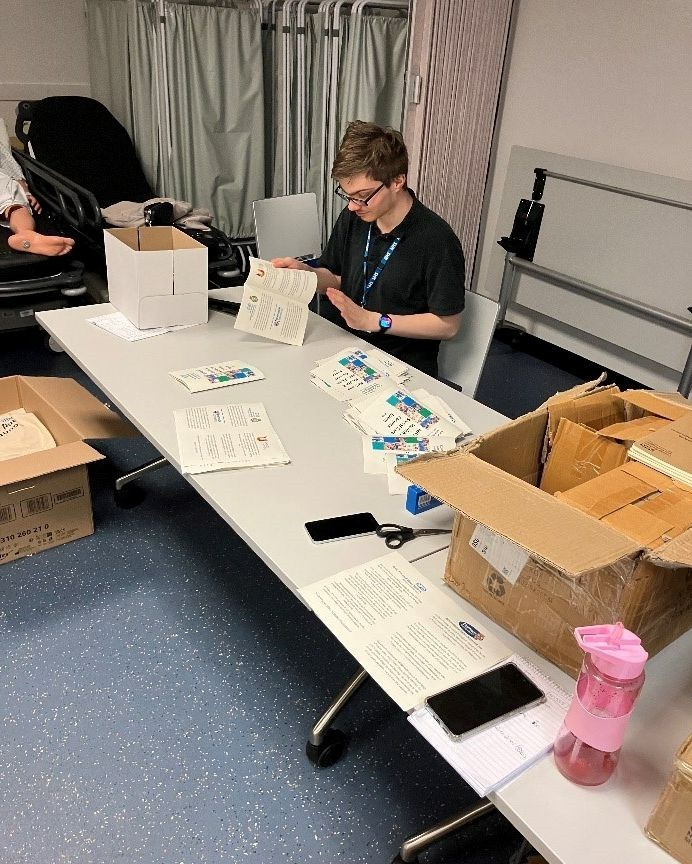 Man sat a desk sorting through leaflets