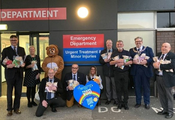 People holding teddy bears smiling outside of the emergency department