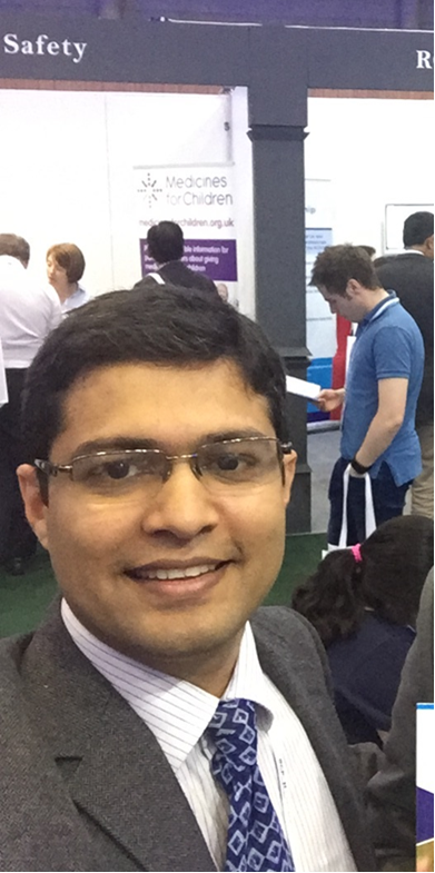Man in suit smiling in a busy room
