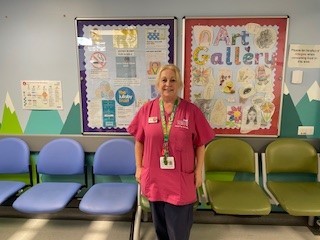 Woman in pink scrubs in emergency department wwaiting room
