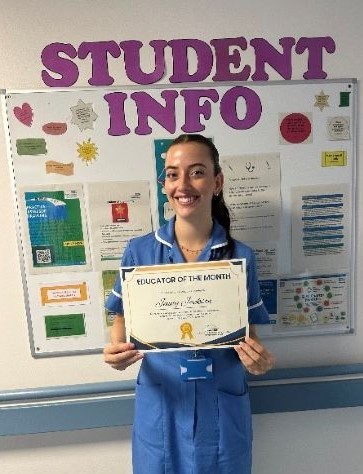 Nurse in uniform smiling holding a certificate