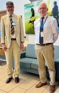 Tall man with smaller man smiling