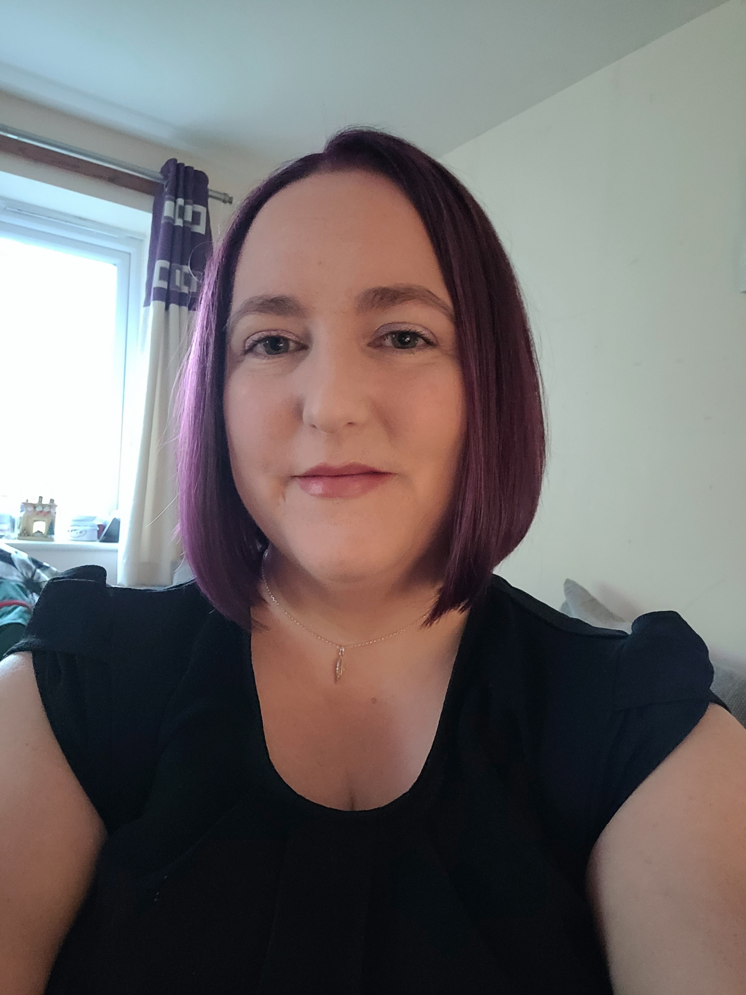 Woman with short hair in black top smiling