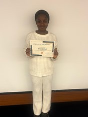 Woman waring white smiling holding a certificate