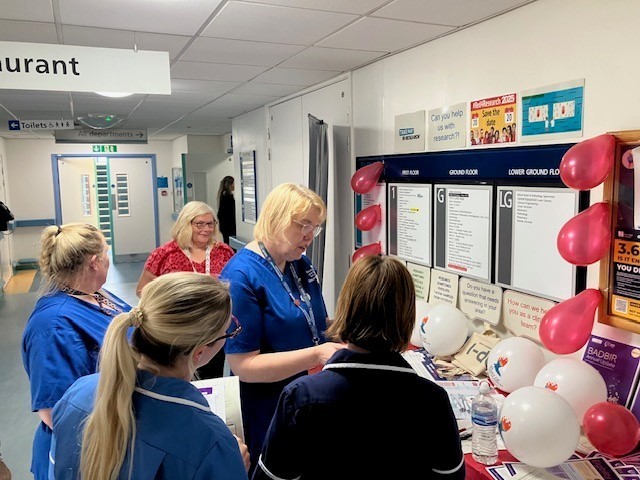 Nurses at information stand reading