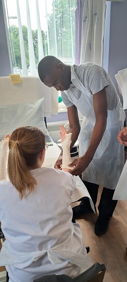 Student puts on a dressing on a patient