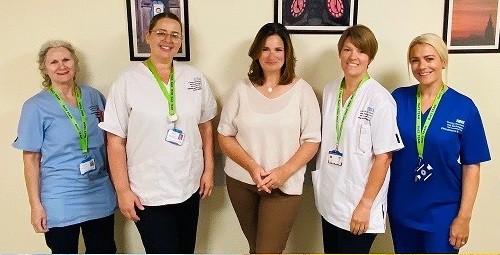 Clinicians ins crubs smiling on a ward
