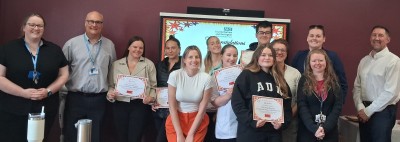 Group of students smiling holding certificates