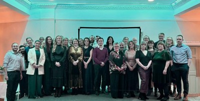 Men and women smiling on a stage at awards