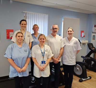 Medical staff in scrubs smiling on a ward