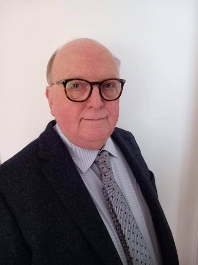 White man in suit smiling