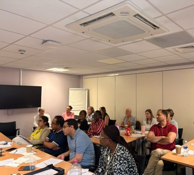 People in a room at desks watching a presentation