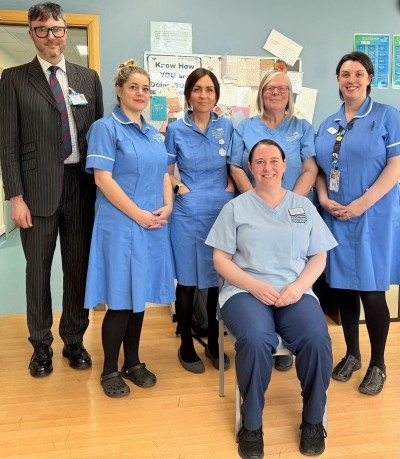 Tall man with smaller people smiling in dental surgery