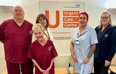 Photo of staff standing in front of signage for urgent care centre at shotley bridge hospital