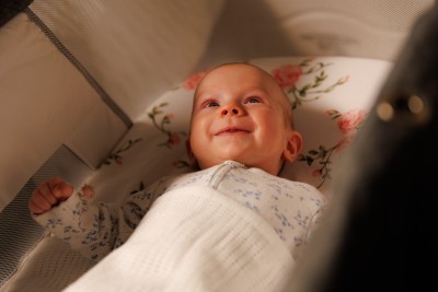 Close up of baby smiling in cot