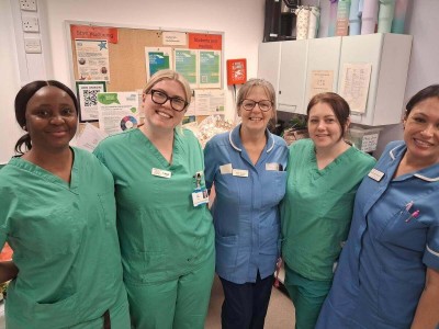 Women in scrubs smiling next to food