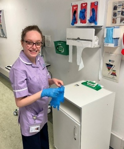 Woman in purple smiling putting gloves on
