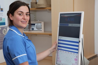 Female nurse pictured using the AIVI software on a computer