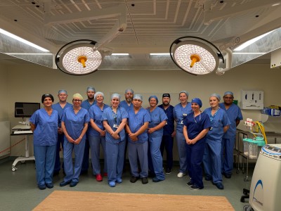 Theatre staff in scrubs smiling in a group in theatre