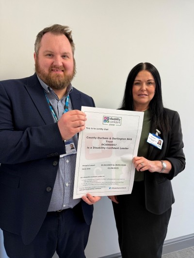 Man and woman holding certificate between them and smiling