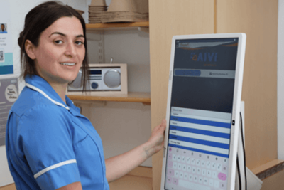 Female nurse pictured using the AIVI software on a computer