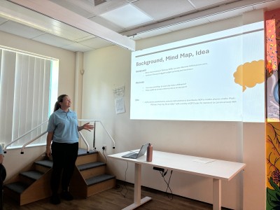Woman in blue top presenting to a room